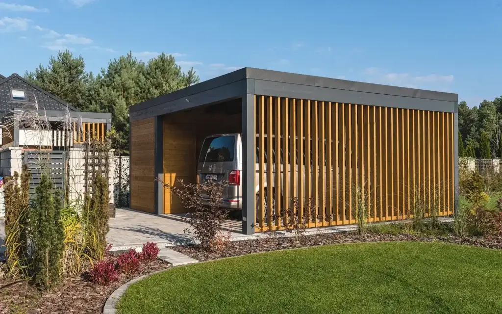 Nowoczesny drewniany carport z pomieszczeniem gospodarczym i stanowiskiem na jeden samochód.